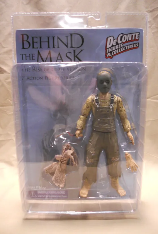 The 7-inch Leslie Vernon action figure sealed in its DeConte Figures & Collectibles blister packaging, with an alternate burlap head, an extra hand and a hand scythe inside